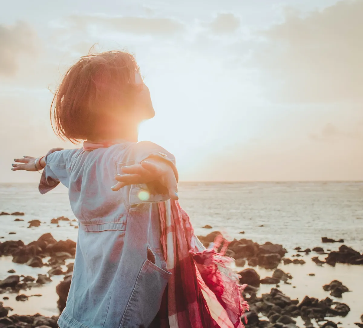 Woman at beach with horizon in background. Photo by Fuu J on Unsplash
